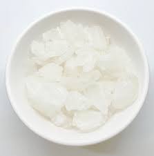 Raw Suhaga (Borax) crystal pieces on a wooden surface – traditional Ayurvedic mineral used in spiritual rituals and home remedies.